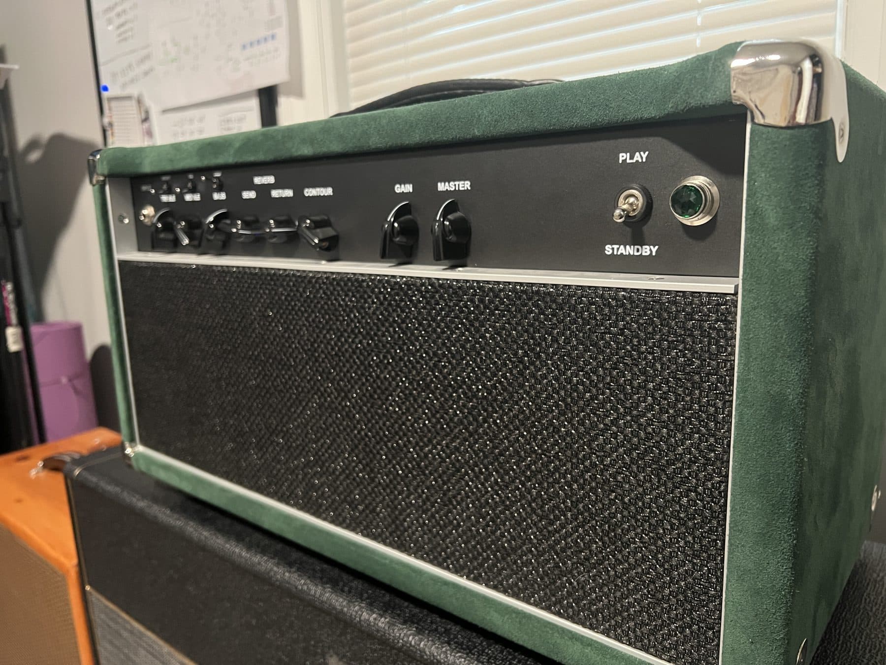 Close-up of a green suede head with gain, master and standby controls