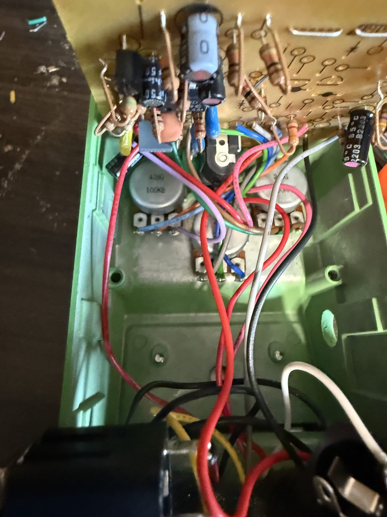 Inside of an effects pedal showing pots, wiring and circuit board